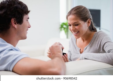 Young man making a proposal to his girlfriend on the sofa