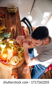 Young Man Making Smoothie On A Table On A Sunny Day.