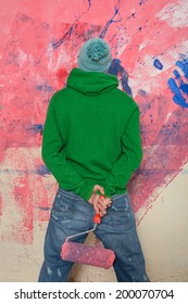 young man making a total mess from painting a wall