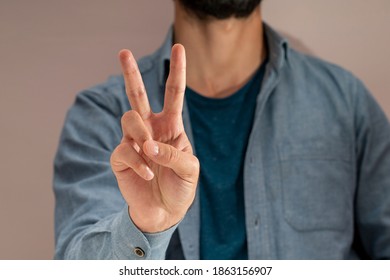 Young Man Making Two Signs With His Fingers