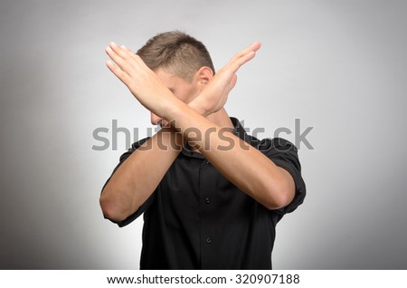 Young man making X shape for Extreme with his hands.
