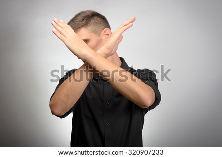 Young man making X shape for Extreme with his hands.