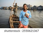 A young man in Makoko carrying his fishing net over his shoulder, with another fisherman standing behind, paddling the boat through the calm river, showcasing the tradition of fishing in the village.