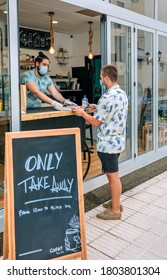 Young Man With Mask Picking Up A Take Away Food Order