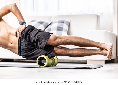 Young Man Massage Lateral Thigh Muscle With Foam Roller.