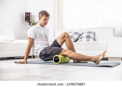 Young Man Massage Thigh Muscle With Foam Roller.