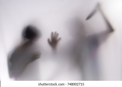 Young man Mayhem behind frosted glass.image creates feeling of fear,Behind a screen,Blurry shadow