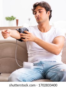 Young Man Measuring Blood Pressure At Home