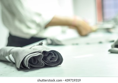 Young Man Measuring And Cutting Leather In Workshop
