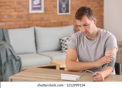 Young Man Measuring His Blood Pressure At Home