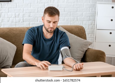 Young Man Measuring His Blood Pressure At Home