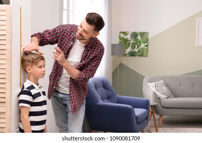 Young man measuring his son's height at home - Powered by Shutterstock