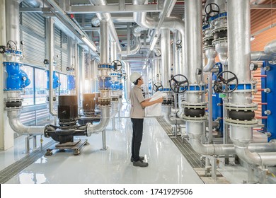 Young man mechanical engineer holding drawing to checking and inspection of HVAC heating ventilation air conditioning system and pipping line of industrial construction at boiler pump room system - Shutterstock ID 1741929506
