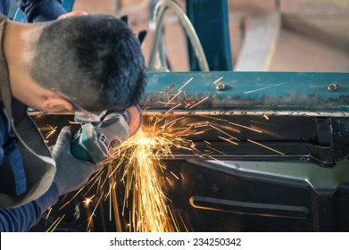 Young man mechanical worker repairing an old vintage car body in messy garage - Safety at work with protection wear - Powered by Shutterstock