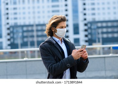 Young Man In A Medical Mask Outside, No Money, Crisis, Poverty, Hardship. Quarantine, Coronavirus, Isolation.