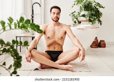 Young Man Meditating In Bathroom