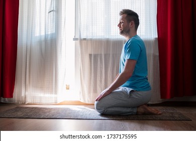 Young man meditating on his living room floor sitting. Stay home and be active. - Shutterstock ID 1737175595