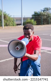 Young man with a megaphone throwing slogans with a brave attitude - Shutterstock ID 2215147741