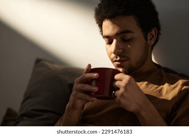 Young man in melancholy enjoying hot coffee and thinking about his life moments - Powered by Shutterstock