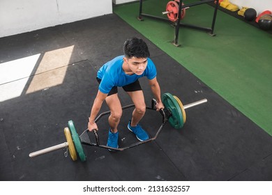 A young man mentally preparing himself for a set of trap bar deadlifts. Upper body workout session at an old hardcore gym.