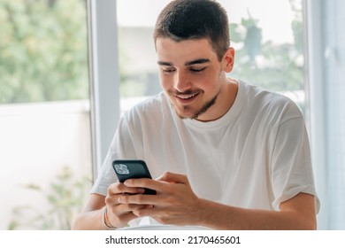young man with mobile phone chatting or playing games