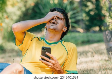 young man with mobile phone laughing out loud