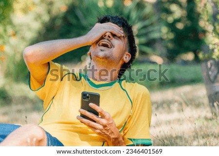 young man with mobile phone laughing out loud