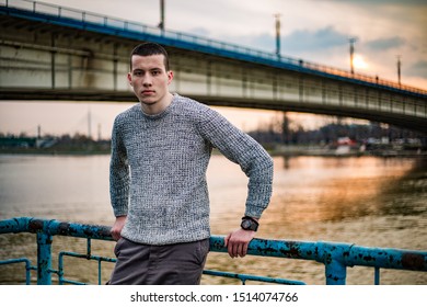 ブランコの橋 サヴァ川 夕日を背景に フェンスに寄りかかりながらポーズをとるセーターの青年モデル の写真素材 今すぐ編集