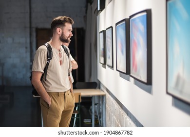 Young man in modern art exhibition gallery hall contemplating artwork. Abstract painting - Shutterstock ID 1904867782
