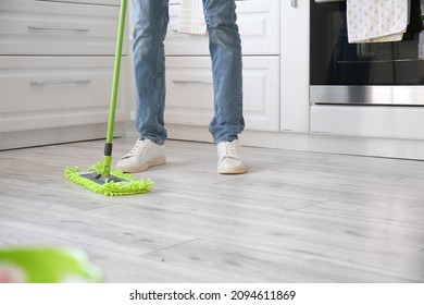 Young Man Mopping Floor In Kitchen