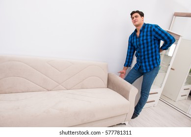 Young man moving sofa couch