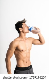 Young Man With Muscular Body Holding A Bottle And Drink With One Hand Stand Facing Side On Isolated Background