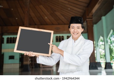 Young Man Muslim Holding And Pointing Black Blank Board