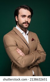 Young Man With Mustache Standing With Crossed Arms On Dark Green