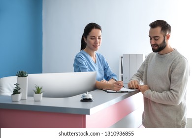 Young man near reception desk in clinic