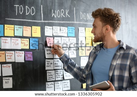 Young man near scrum task board in office [[stock_photo]] © 