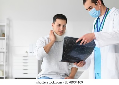 Young man with neck injury visiting doctor in clinic - Powered by Shutterstock