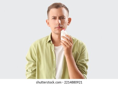 Young Man With Nosebleed And Tissue On White Background