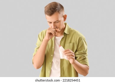 Young Man With Nosebleed And Tissue On White Background