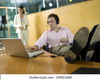 Young Man In Office, Feet On Desk