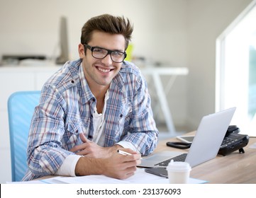 Young Man In Office Working On Laptop Computer