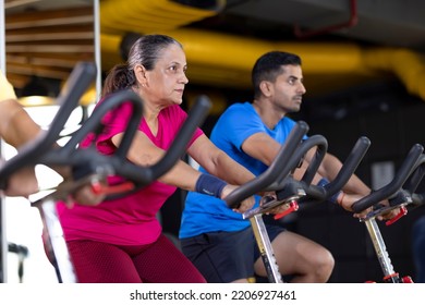  Young man and old woman in sportswear cycling at gym - Powered by Shutterstock