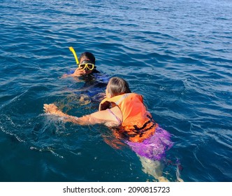 Young Man And Older Woman Snorkeling