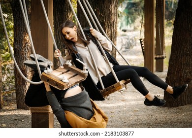 A young man on a date unsuccessfully fell from a swing in the park. Girl in disbelief. High quality photo