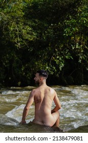 young man on his back in the river completely naked, connecting with nature, with the environment, vertical photo