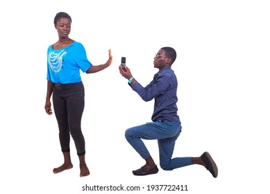 young man on his knees offers a mobile phone as a gift to his girlfriend, woman refuses to pick up the phone.