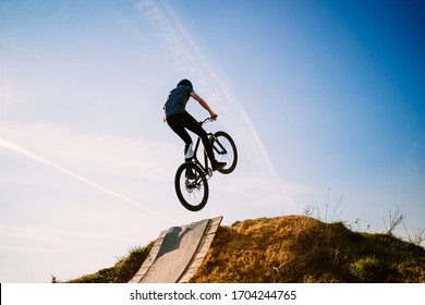 Young Man On A Mountain Bike Performing A Dirt Jump