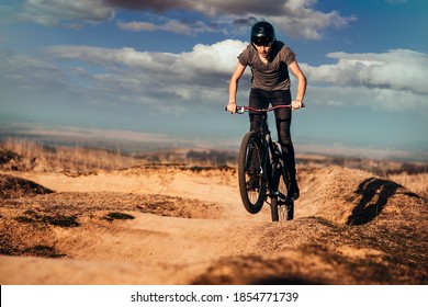 Young Man On A Mountain Bike Performing A Dirt Jump