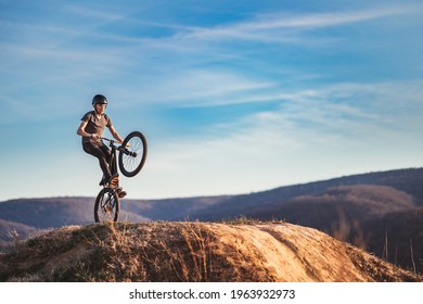 Young Man On A Mountain Bike Performing A Dirt Jump