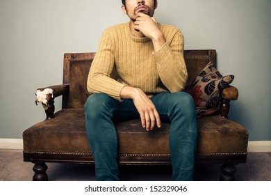 Young Man On Old Sofa Is Thinking